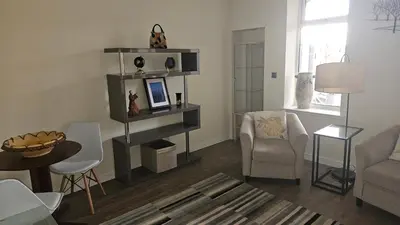 a living room with a couch and a table and chairs at Harbour Havens Apartments in Moffat