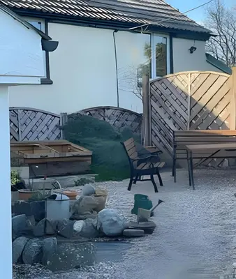 a patio with a bench and a chair and water at Cozy Cottage in Caldbeck in Caldbeck