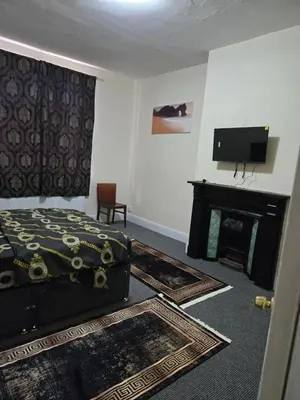 a bedroom with a bed and a tv and a fireplace at Carlton road in Moffat