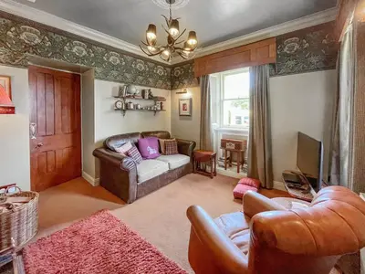 a living room with a couch and a tv at Upper Double Lodge in Kirkcudbright