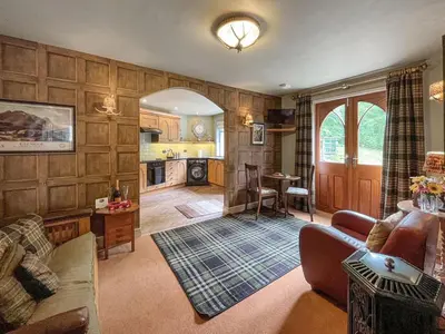 a living room with a couch and a table at Upper Double Lodge in Kirkcudbright