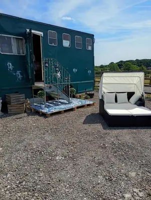 a green trailer with a couch in front of it at The Box in Moffat