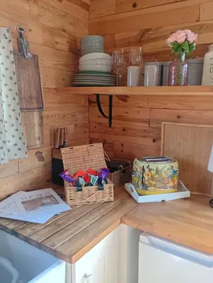 a kitchen with wooden walls and a counter with baskets at The Box in Moffat