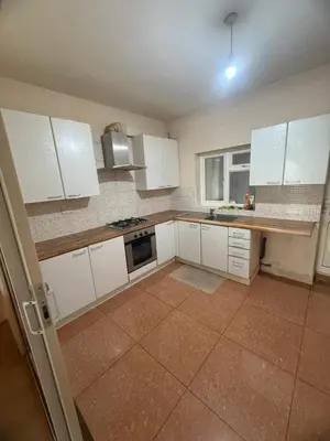 a kitchen with white cabinets and a tile floor at Harrow Inn Rooms in Yarrow