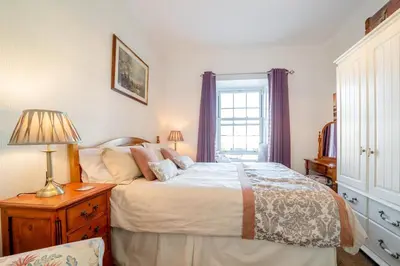 a bedroom with a bed and a lamp and a window at 2 Bed in Moffat oc-a32121 in Moffat