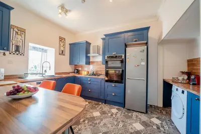 a kitchen with blue cabinets and a table with a bowl of fruit at 2 Bed in Moffat oc-a32121 in Moffat
