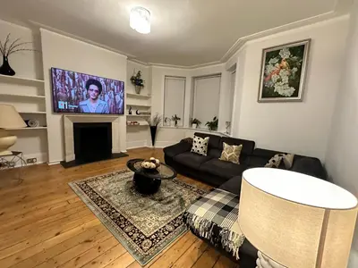a living room with a couch and a flat screen tv at Cosy Double Bedroom in Little Venice, Maide Vale in Moffat
