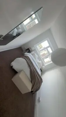 a bedroom with a bed and two windows at Home stay in Moffat