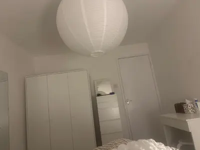 a white room with a white lamp and a mirror at Home stay in Moffat