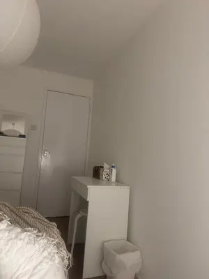 a white bedroom with a bed and a desk at Home stay in Moffat