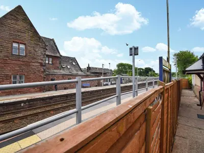 a train station with a fence and train tracks at Station House in St Bees