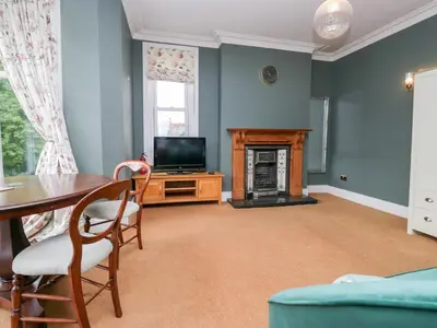 a living room with a table and a television at Sunnycroft in Keswick