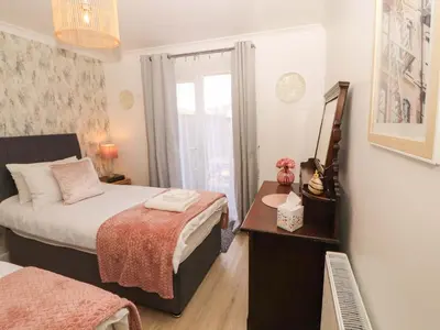 a bedroom with a bed and a table with a mirror at The Paddock in Kirkcowan