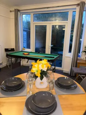 a dining room table with a green pool table at Modern 3BR House Near Manchester-Parking Included in Moffat