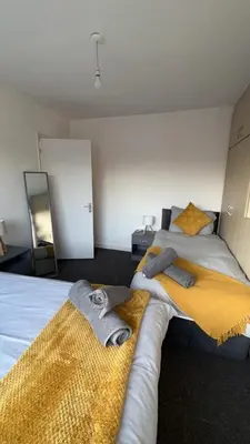 a bedroom with two beds with towels on them at Modern 3BR House Near Manchester-Parking Included in Moffat