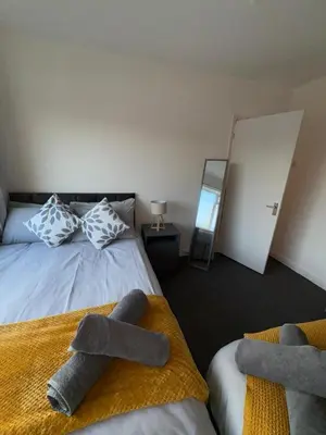 a bedroom with two beds with towels on them at Modern 3BR House Near Manchester-Parking Included in Moffat