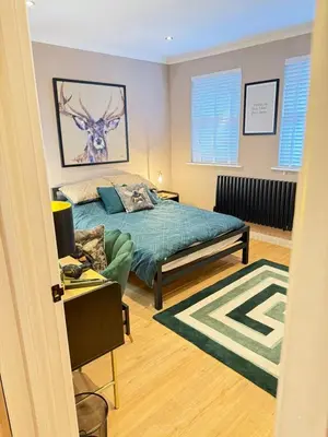 a bedroom with a bed with a deer on the wall at Modern House Maryport Sleeps 6 in Maryport