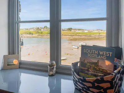 a book sitting on a table in front of a window at Ninians Landing in Kirkcudbright