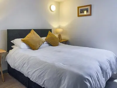 a bedroom with a large white bed with two pillows at Ninians Landing in Kirkcudbright