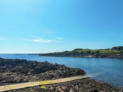 a body of water next to a rocky shore at Ninians Landing in Kirkcudbright