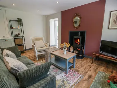 a living room with a couch and a fireplace at Nithbank Cottage in Thornhill