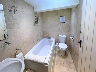 a bathroom with a tub and a toilet and a sink at Old Corner Barn Lake District Escape by PolkaStays in Penrith