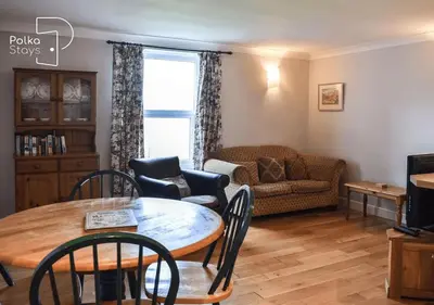 a living room with a table and a couch at Crag Barn Cottage Lake District by PolkaStays in Penrith