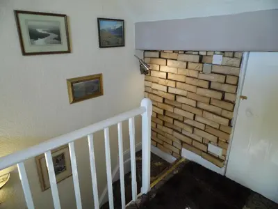 a staircase with a brick wall and pictures on the wall at 2 Bedroom & 2Bathrooms in Lancaster in Moffat