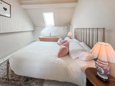a bedroom with a large white bed with two girls laying on it at Three Chapel Court in Cockermouth