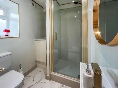 a bathroom with a shower and a toilet and a sink at Three Chapel Court in Cockermouth