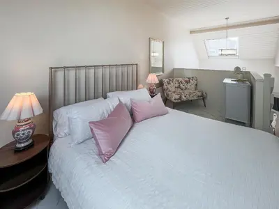 a bedroom with a white bed with pink pillows at Three Chapel Court in Cockermouth