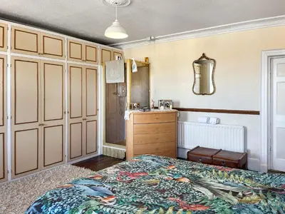 a bedroom with a bed and a dresser at Midtown House in Aspatria