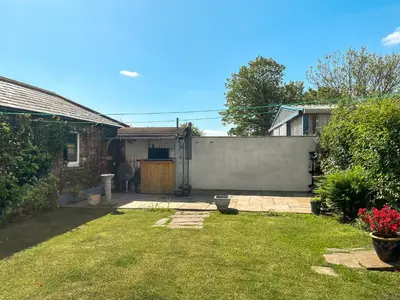 a yard with a fence and a house at Midtown House in Aspatria