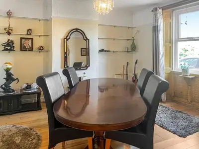 a dining room with a wooden table and black chairs at Midtown House in Aspatria