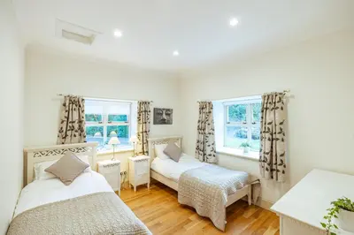 a bedroom with two beds and two windows at Mid Lodge, Penninghame Estate in Challoch