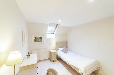 a small bedroom with a bed and a lamp at Penninghame Estate - Bruce Apartment in Challoch