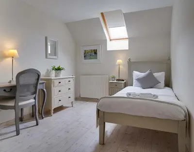 a bedroom with a bed and a desk and a chair at Penninghame Estate - Wallace Apartment in Challoch