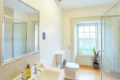 a bathroom with a sink and a toilet and a mirror at Penninghame Estate - Stewart Apartment in Challoch