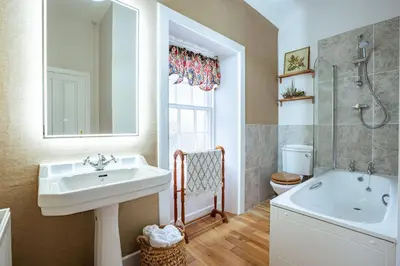 a bathroom with a sink and a tub and a toilet at Penninghame Estate- Gardeners Cottage in Challoch