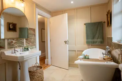 a bathroom with a tub and a sink and a toilet at Penninghame Estate - Earl's Library in Challoch