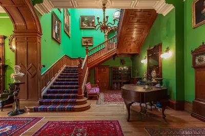 a room with a staircase and green walls at Penninghame Estate - Tower Apartment in Challoch