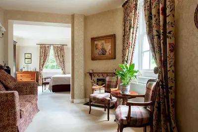 a living room with a couch and a room with a bed at Knockinaam Lodge in Portpatrick