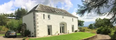 a white house with a car parked in front of it at The Coach House at Durhamhill with llamas & games room mini cinema in Kirkpatrick Durham