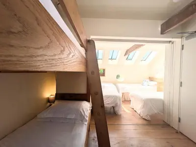 a room with two bunk beds and a window at The Coach House at Durhamhill with llamas & games room mini cinema in Kirkpatrick Durham