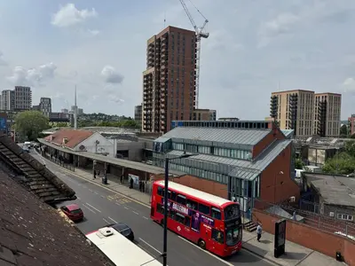 a red double decker bus driving down a city street at Your Base To Explore London in Moffat