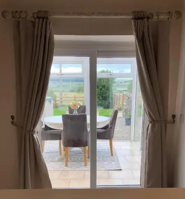 a dining room with a table and chairs and a window at Sycamore Cottage, Western Lakes Bolthole With Views Across the Fells in Arlecdon