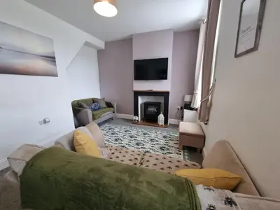 a living room with a couch and a fireplace at Sycamore Cottage, Western Lakes Bolthole With Views Across the Fells in Arlecdon
