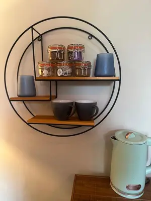 a wall mounted shelf with bowls and jars on it at The Briery in Workington