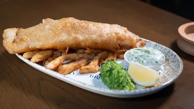 a plate of fish and fries and a side of dip at The Briery in Workington