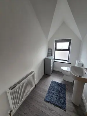 a white bathroom with a sink and a toilet at Central Portrush Townhouse available for Open Golf in Moffat